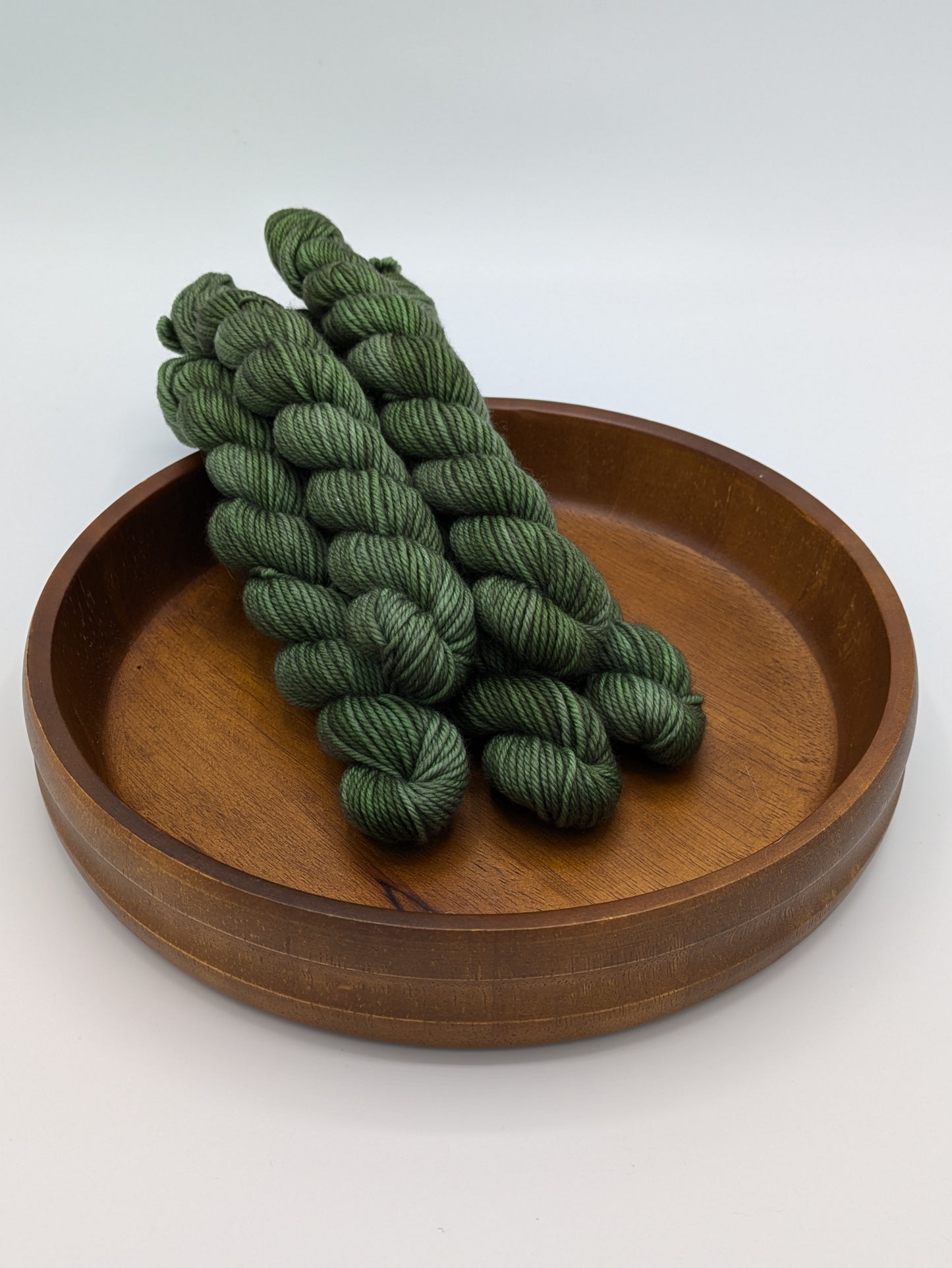 Fir Yarn in 20 gram DK weight mini skein, showcasing a deep forest green color
