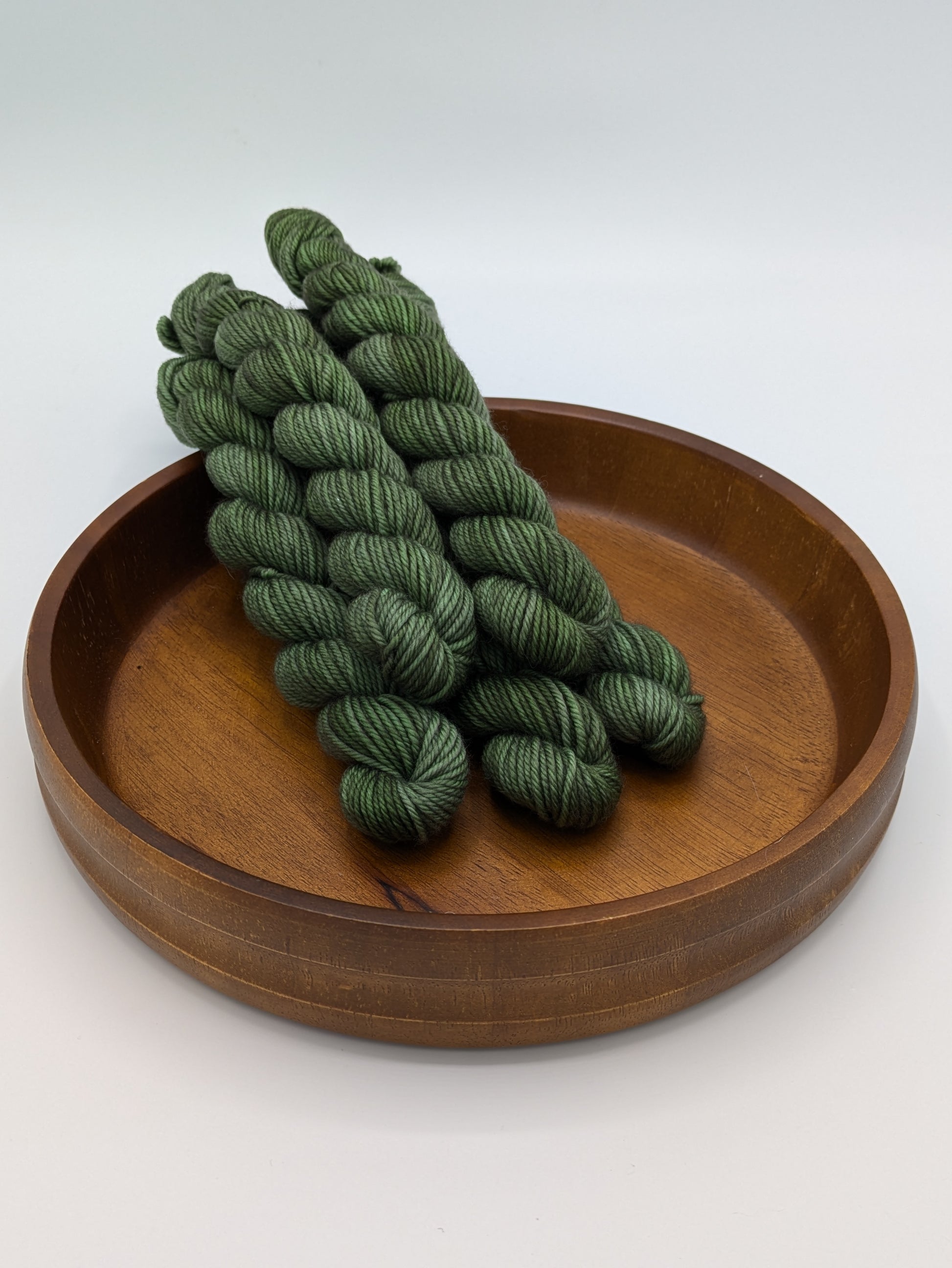 Fir Yarn in 20 gram DK weight mini skein, showcasing a deep forest green color