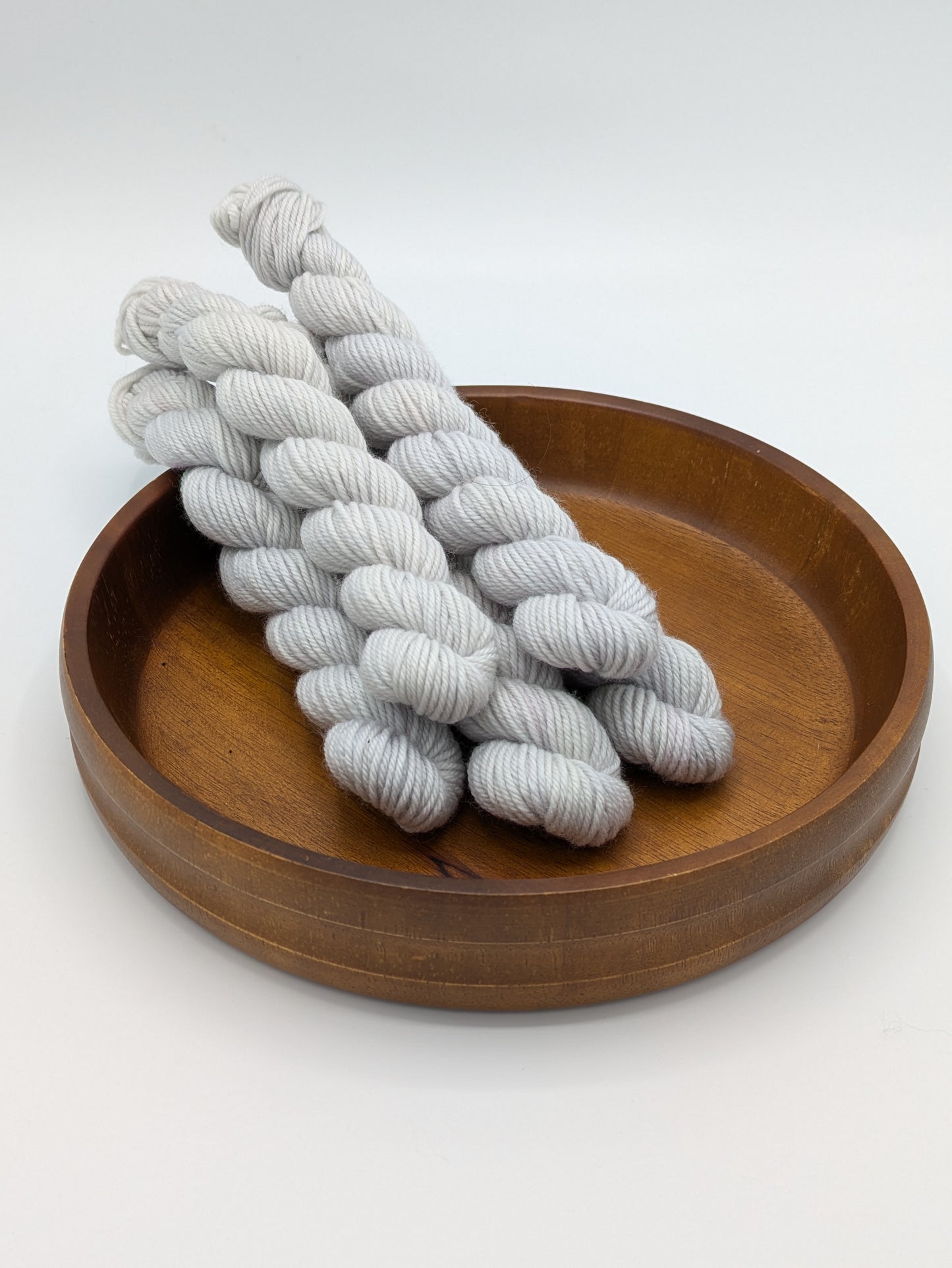 Frost DK weight mini skeins showcasing a neutral gray blue color