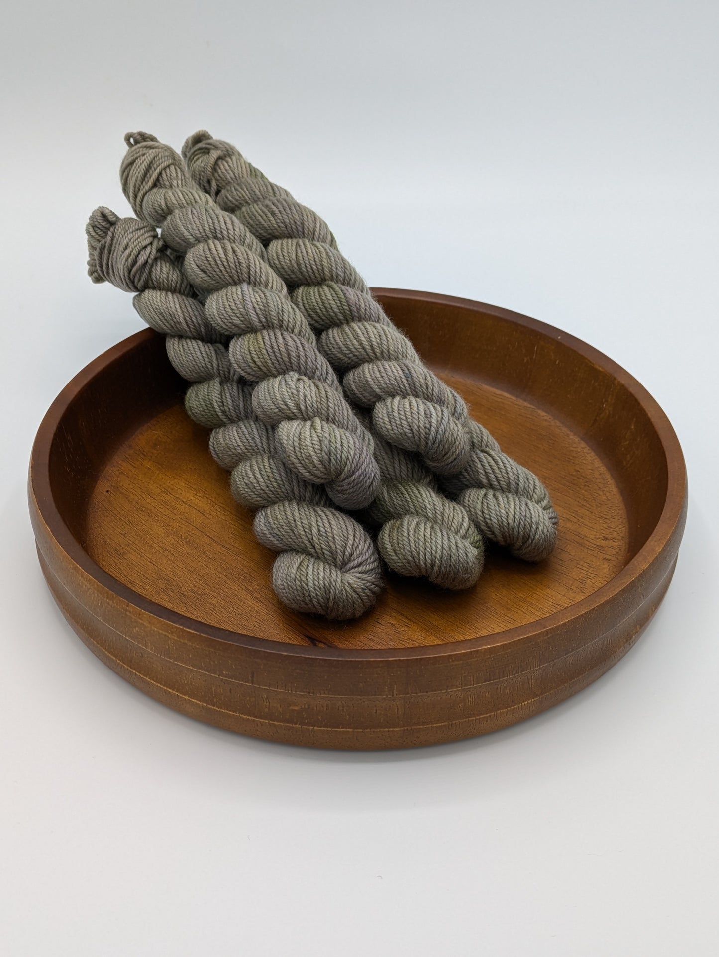 Mud Bath DK weight mini skeins showcasing a neutral tan color with brown and green undertones