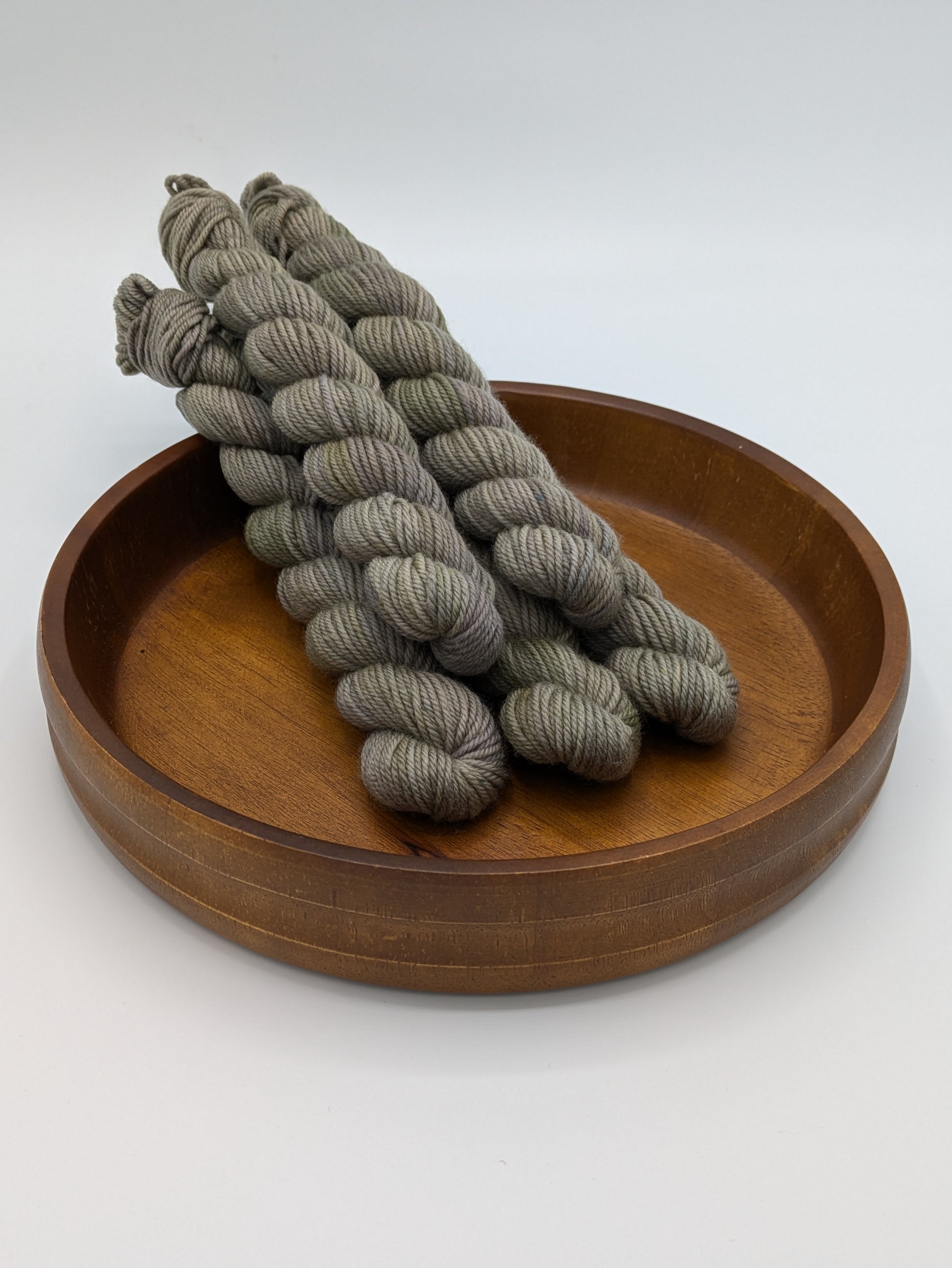 Mud Bath DK weight mini skeins showcasing a neutral tan color with brown and green undertones