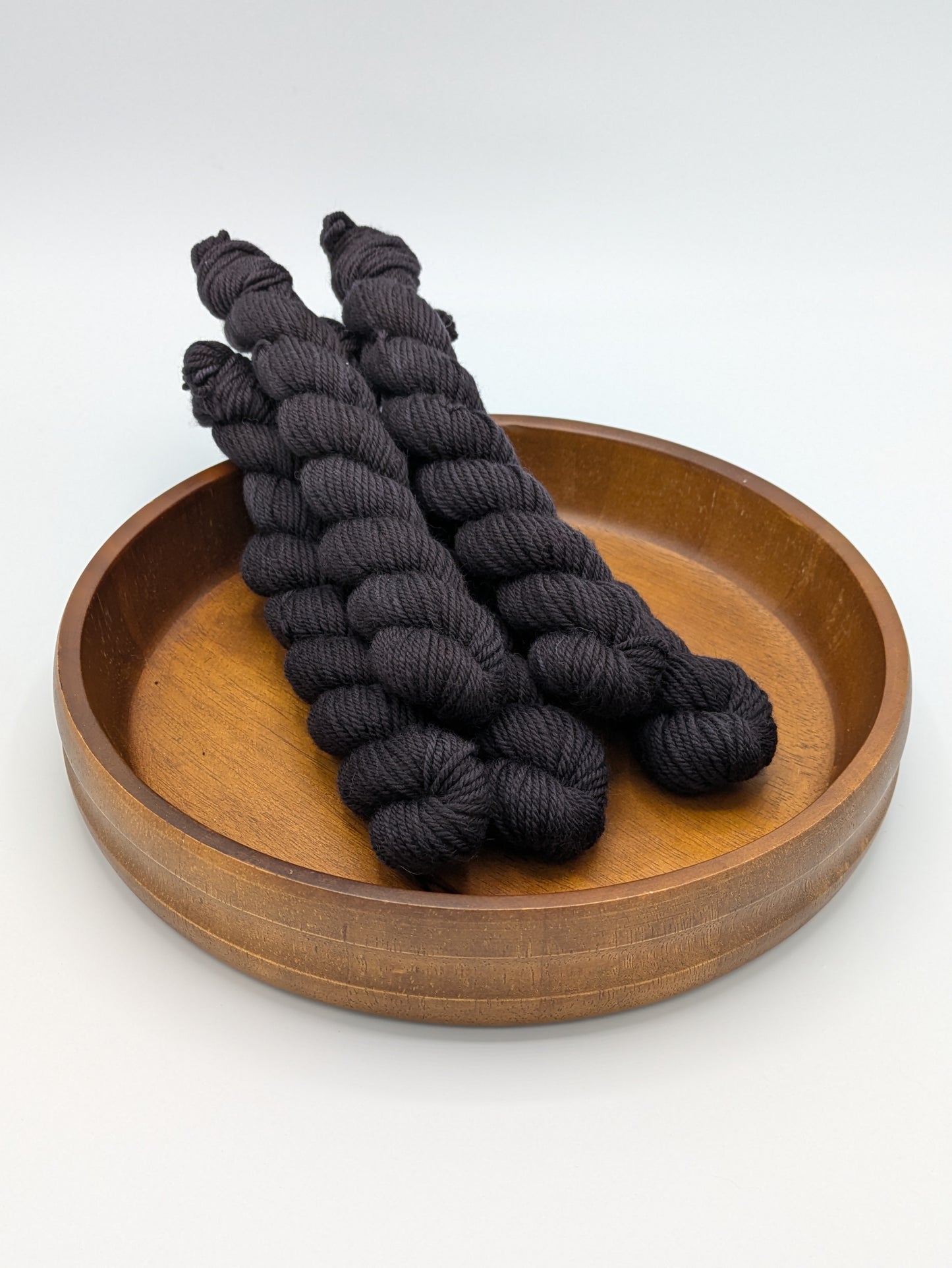 Nocturnal DK weight mini skeins showcasing a dark black color