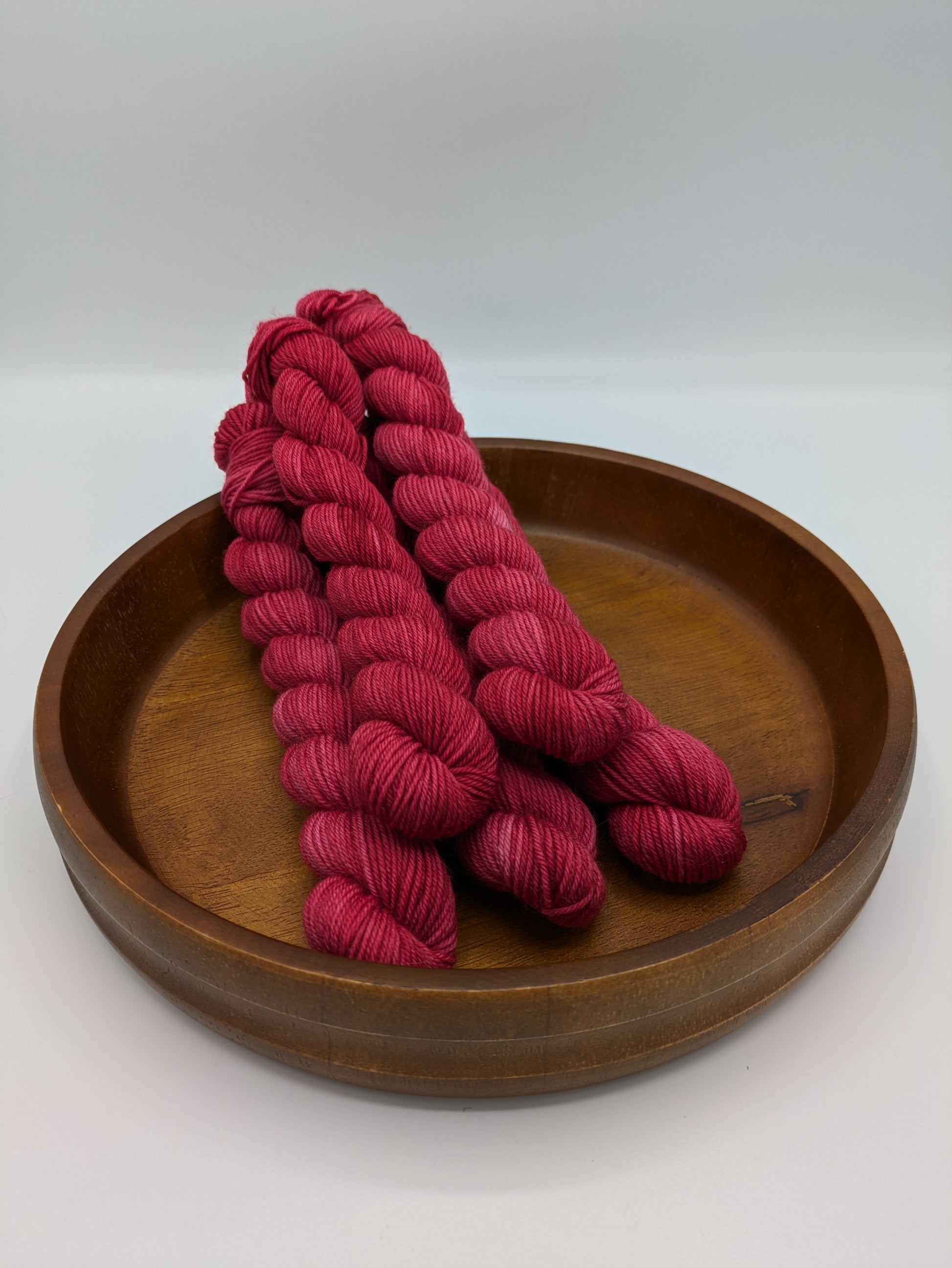 A Good Red Yarn mini skeins in fingering weight, showing vibrant red color