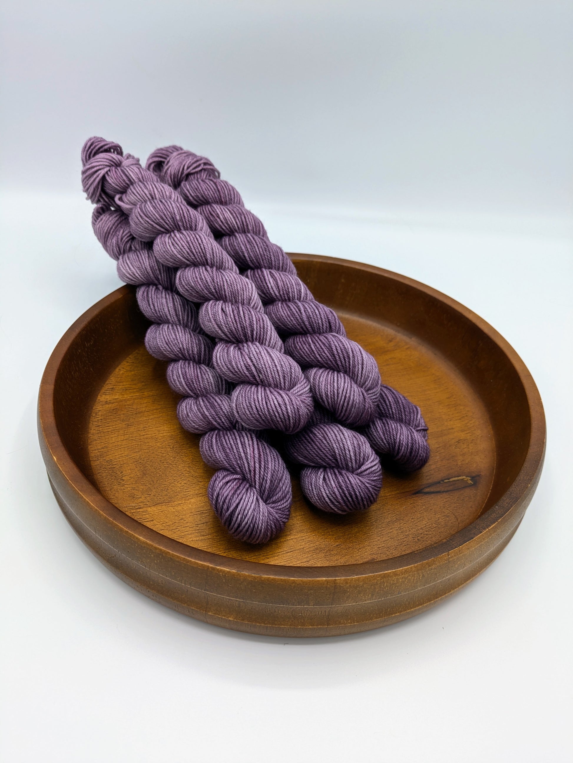 Skeins of Amethyst fingering weight yarn, a soft purple color