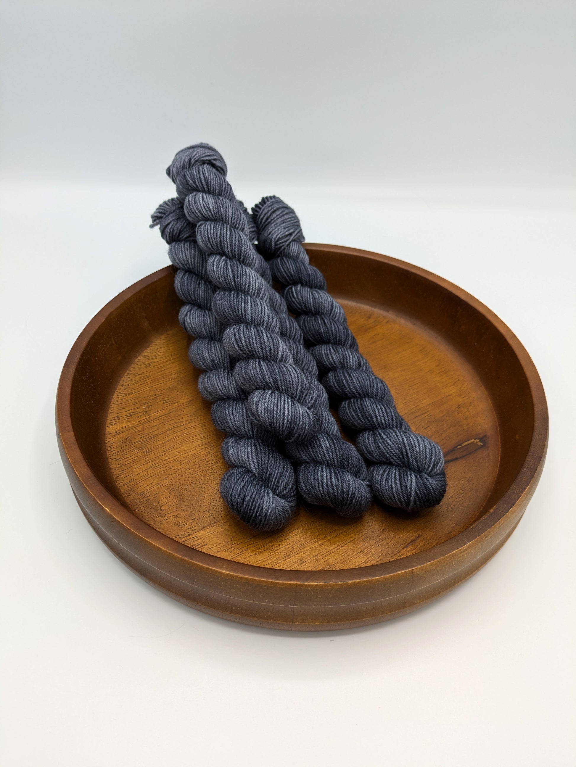 Charcoal fingering weight mini skeins showcasing a neutral dark gray color