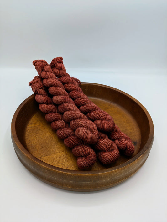 Cinnabar Yarn mini skeins in fingering weight, showing a burnt orange color