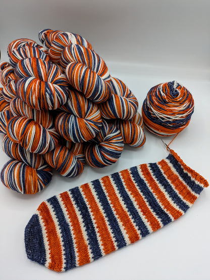 Multicolored yarn skeins and a knitted sock on a white background