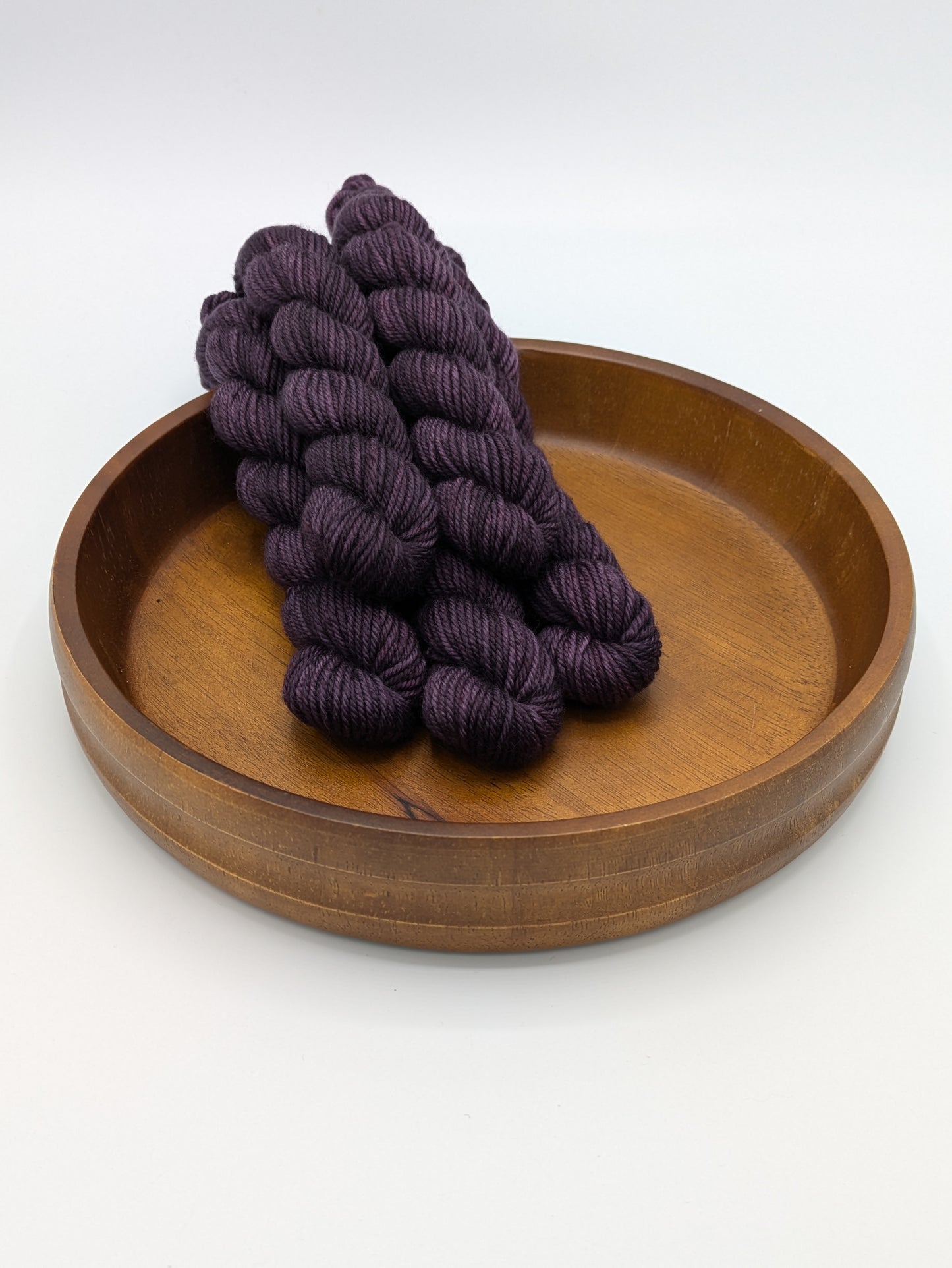 Skeins of Grandma DK weight yarn, a deep dark purple color