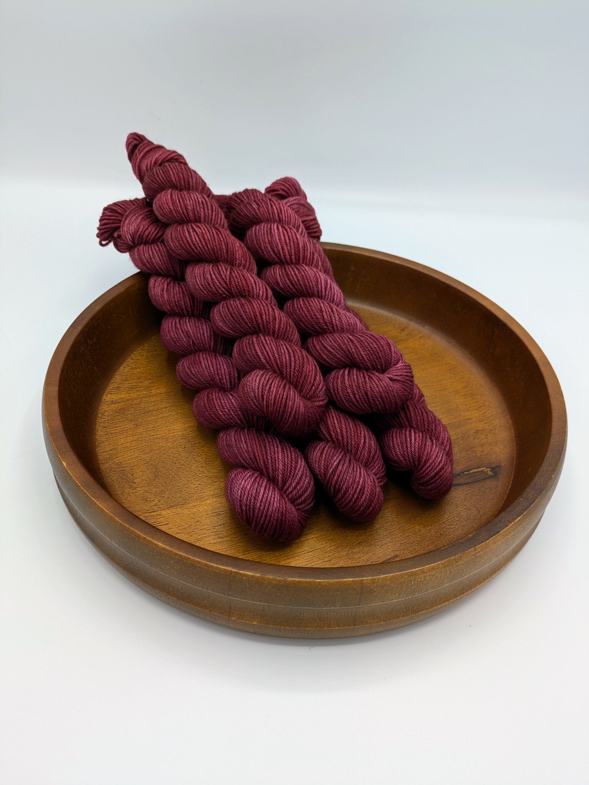 Skeins of Merlot fingering weight yarn, a rich wine color