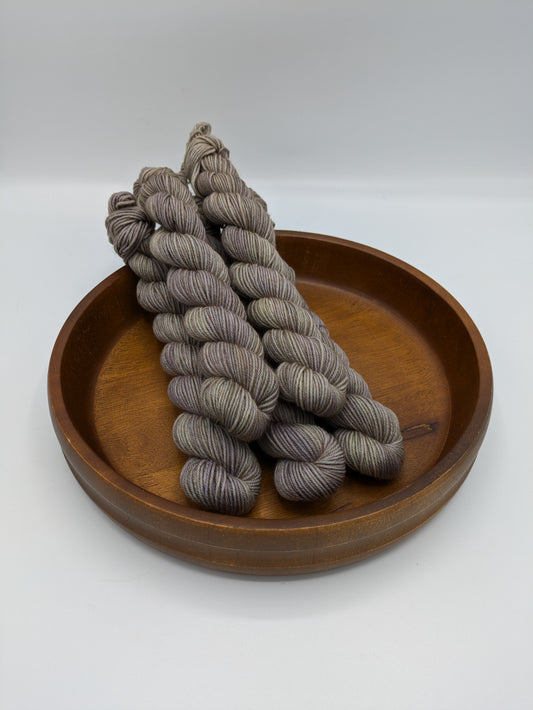 Mud Bath fingering weight mini skeins showcasing a neutral tan color with brown and green undertones