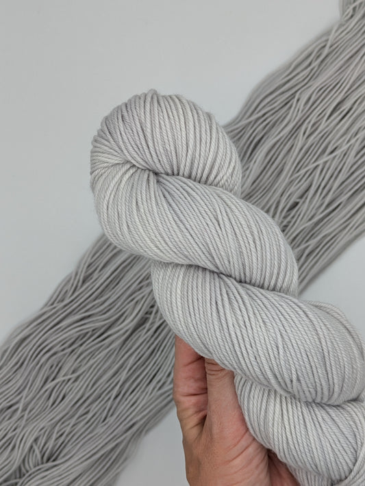 Frost Non-Supewash Yarn skein in DK weight, showcasing a silver white neutral color