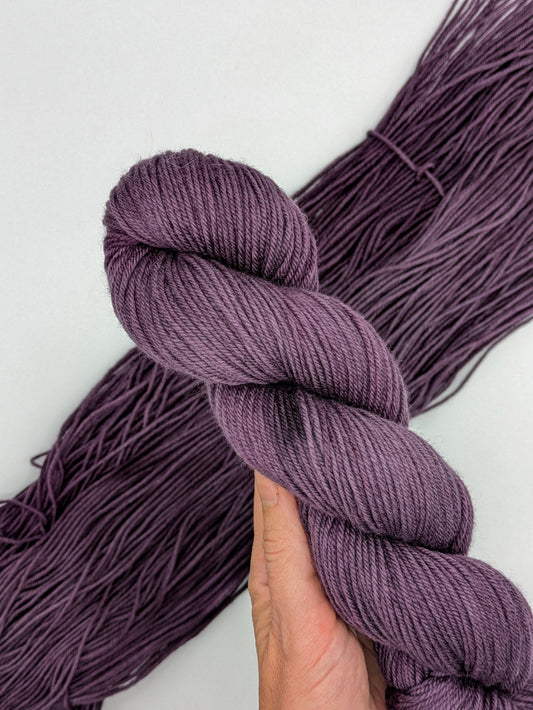 Grandma Yarn skein in non-superwash DK yarn, showcasing hand-dyed purple color