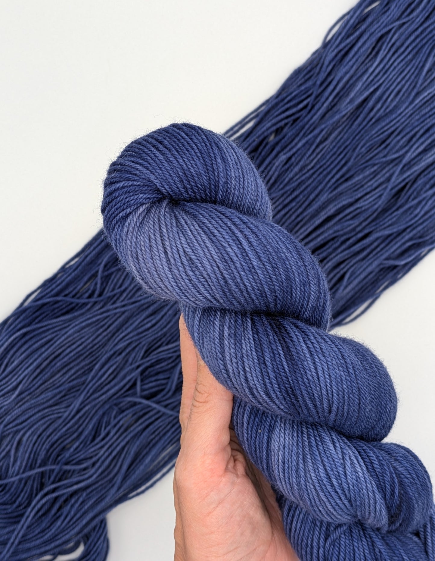 Mountain Shadows Non-Superwash Yarn skein in DK weight, showcasing bold blue color