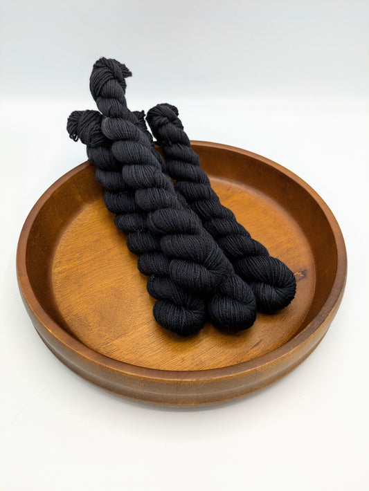 Nocturnal fingering weight mini skeins showcasing a dark black color