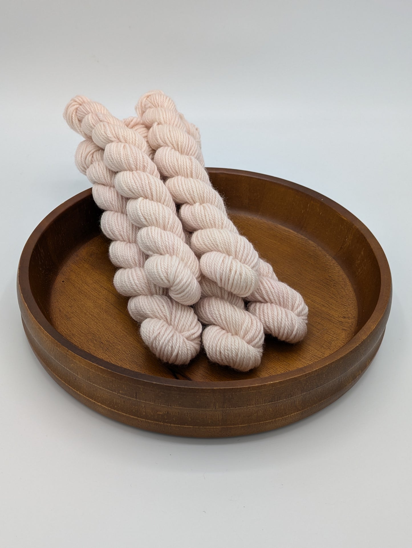 Seashell mini skeins in a DK weight yarn, showing a soft pink color