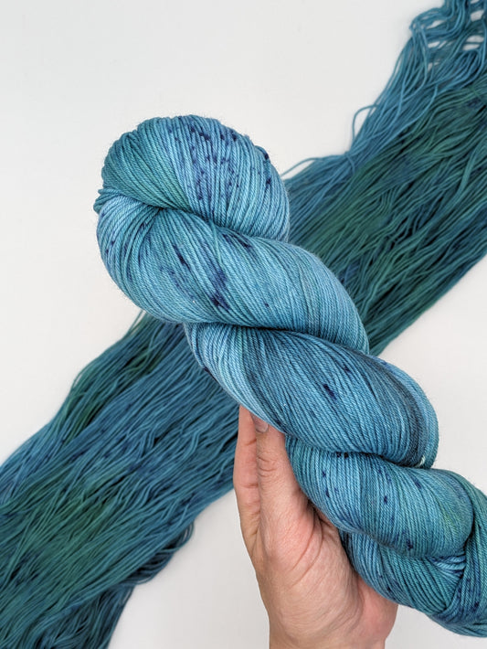 Sprague Lake Yarn skein in fingering weight, showcasing vibrant blue-green hues