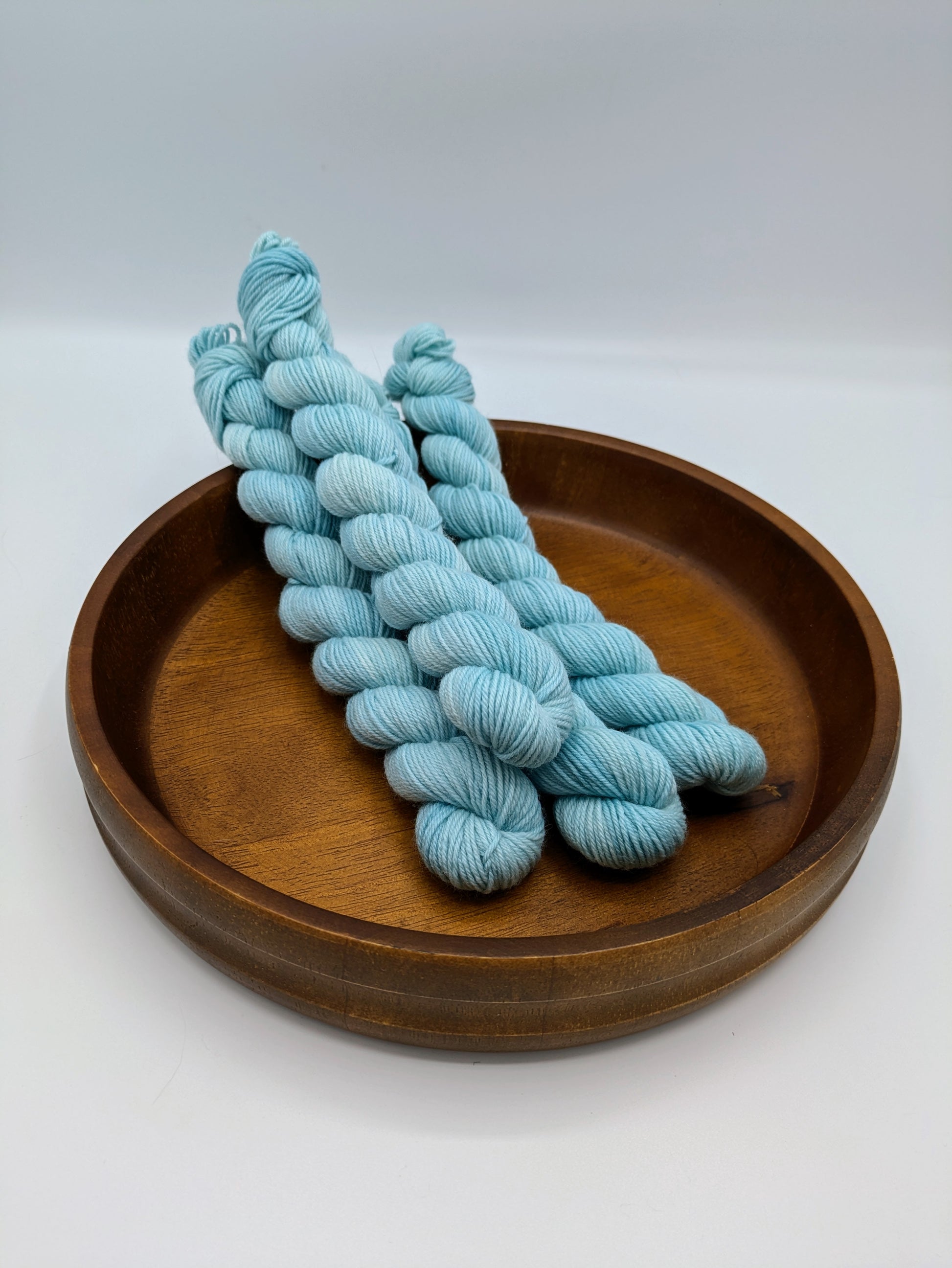 Skeins of Summer Sky fingering weight yarn, a soft sky blue color