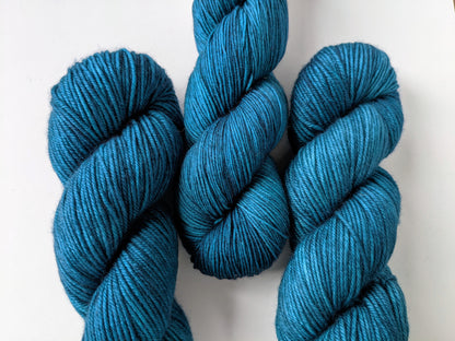 Tealicious Yarn skeins in fingering and DK weights, showcasing vibrant teal color