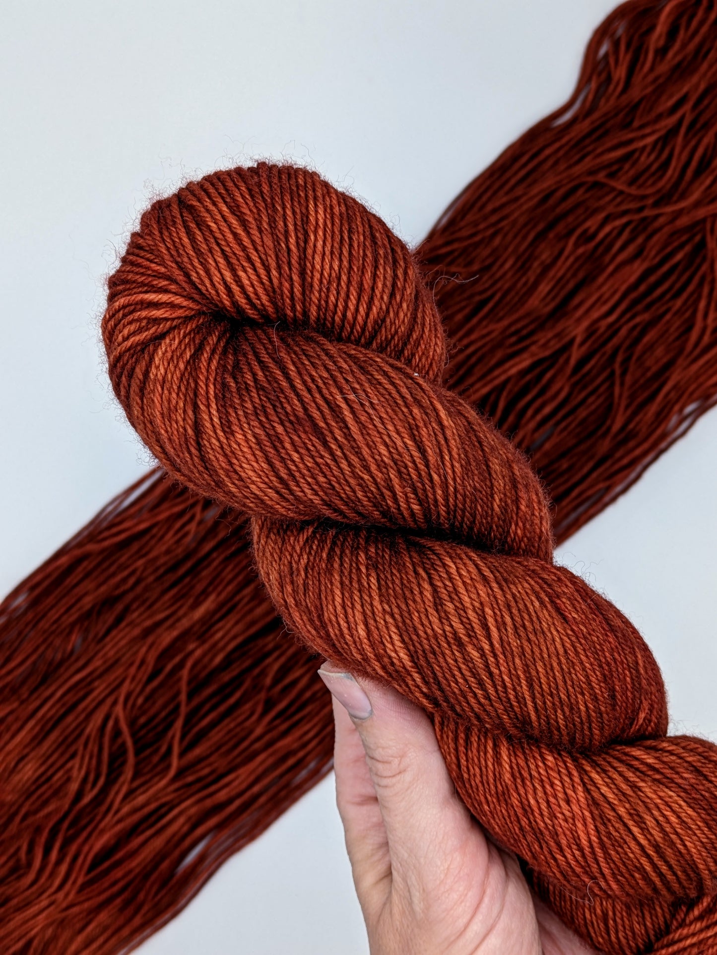 Cinnabar Yarn skein in DK weight, showcasing vibrant orange-red hues