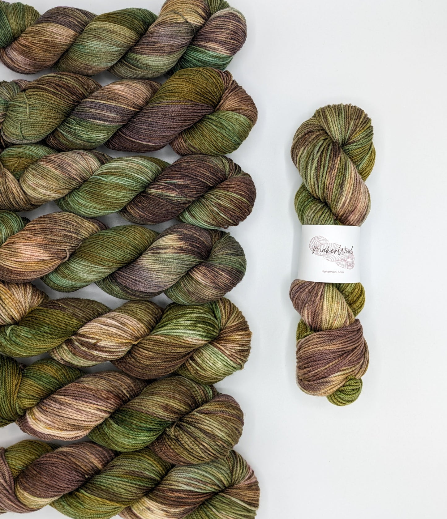 Forest Retreat Yarn skeins in fingering and DK weights, showcasing shades of green and brown