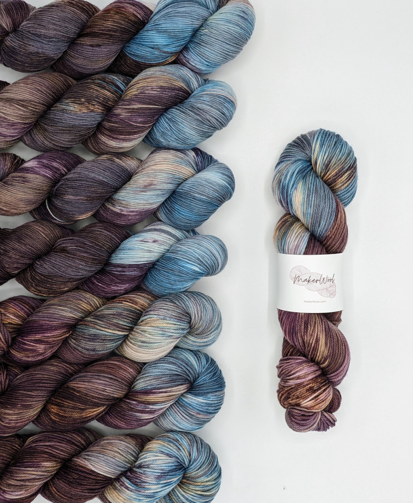 Iris Yarn skeins in fingering, DK and suri silk weights, showcasing vibrant purple and blue hues