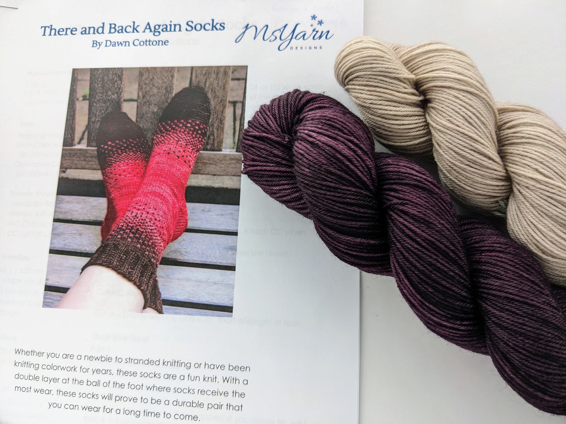 Image of There & Back Again sock knitting kit showing dark purple and tan yarn colors and knitted sock pattern detail