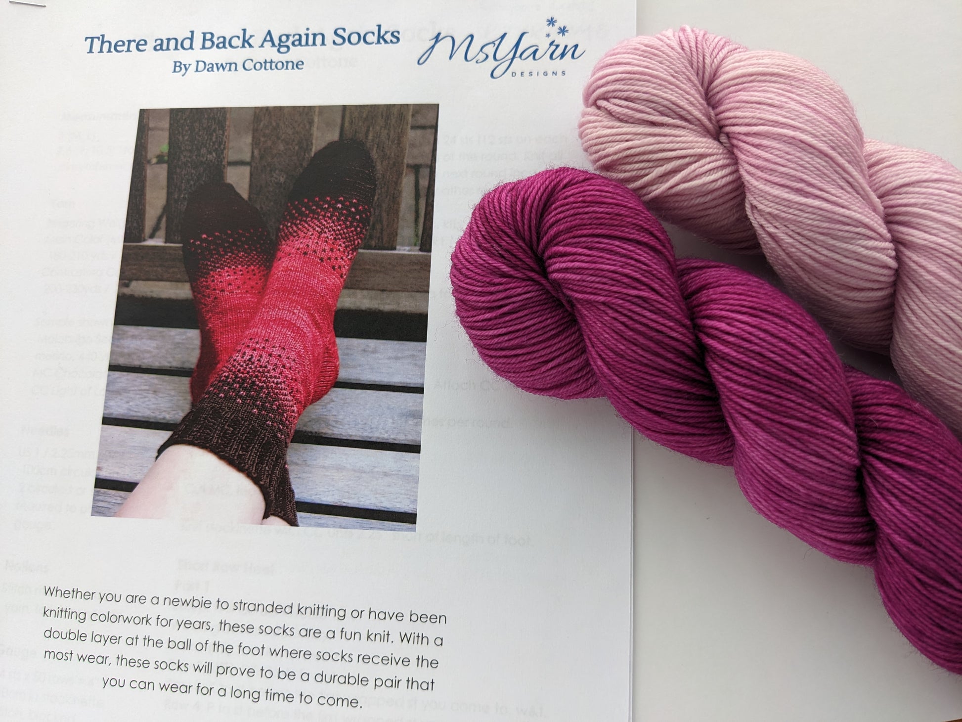 Image of There & Back Again sock knitting kit showing pink and magenta yarn colors and knitted sock pattern detail