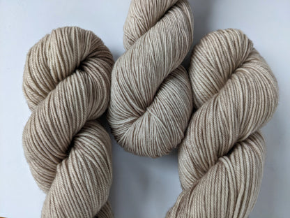 Oatmeal Yarn skeins in fingering and DK weights, showcasing natural color