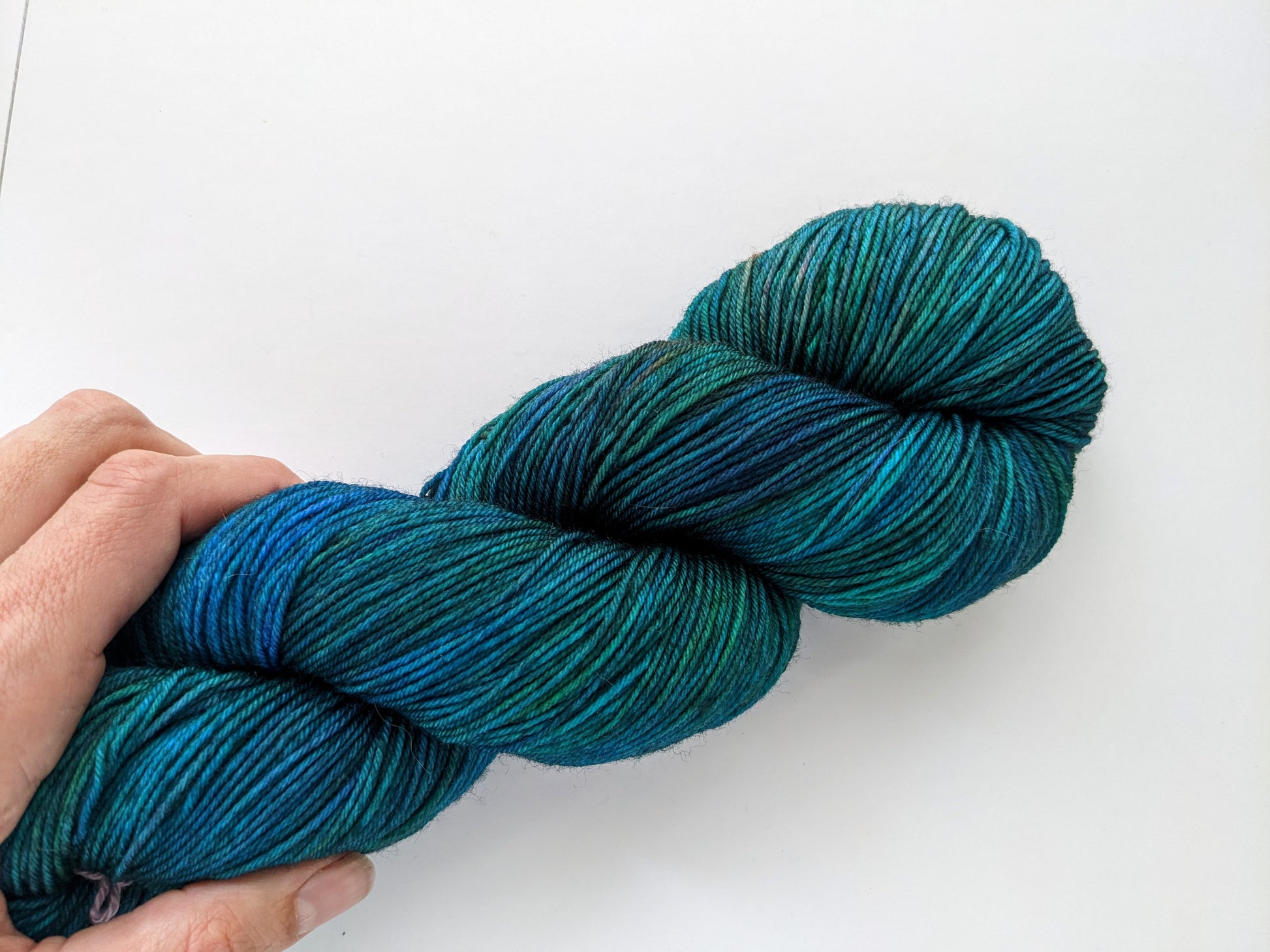 eacock Yarn in fingering weight, showcasing vibrant blue and green hues