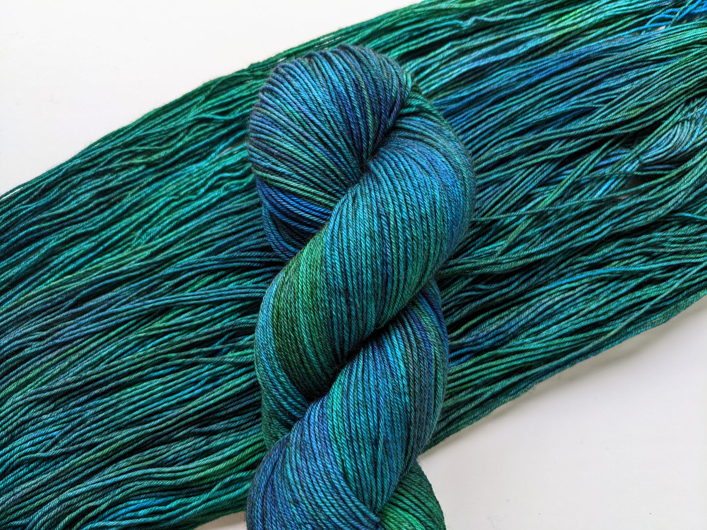 eacock Yarn in fingering weight, showcasing vibrant blue and green hues