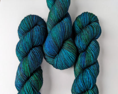 eacock Yarn skeins in fingering and DK weights, showcasing vibrant blue and green hues