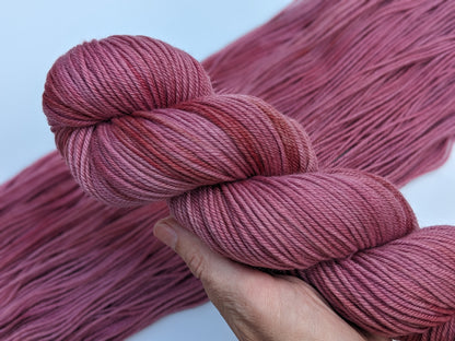 Peony Whisper Yarn skein in non-superwash DK weight, showcasing soft peony pink color