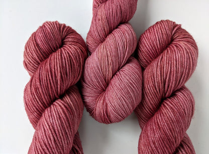 Peony Whisper Yarn skeins group in fingering and DK weights, showcasing soft peony pink color