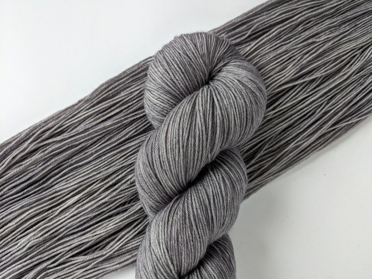 Silver Mist Yarn in fingering weight, showcasing a soft grey color