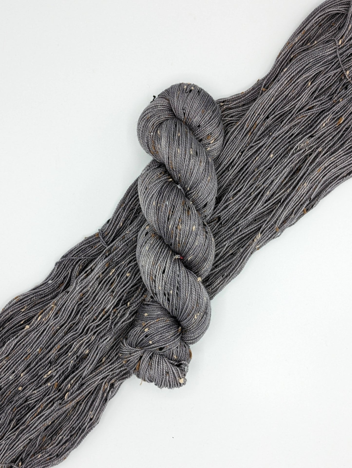 Silver Mist Yarn in tweed fingering weight, showcasing a soft grey color