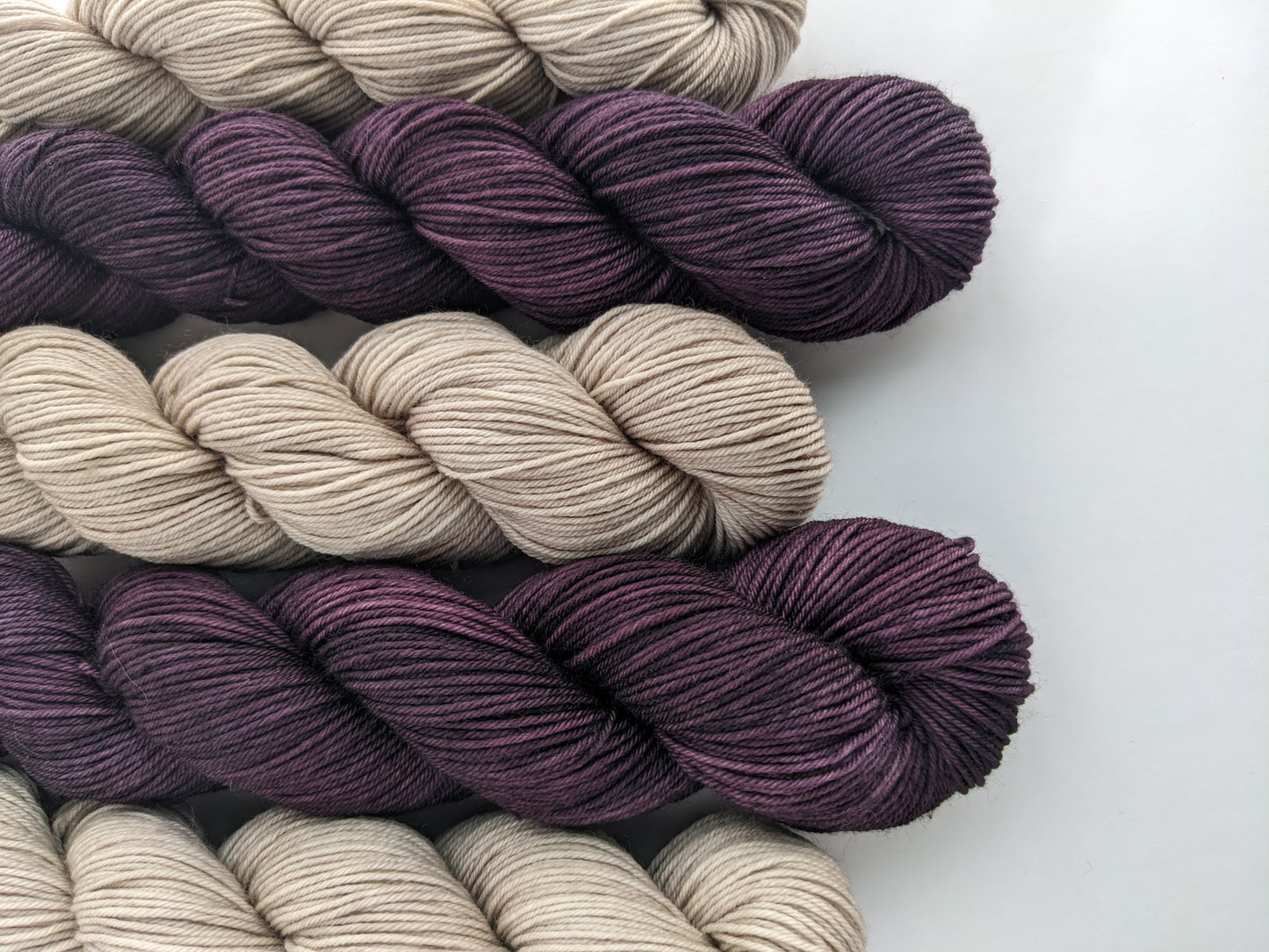 Image of sock yarn skeins showing dark purple and tan yarn colors